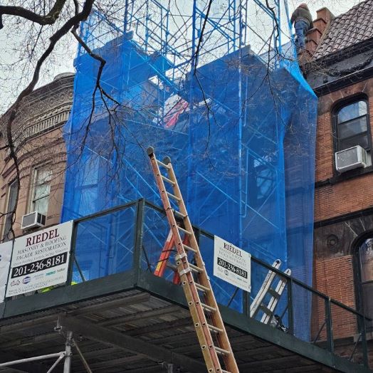 Sidewalk bridge and scaffold erected for work at a residence on West 95th Street in NYC. Spanish terracotta roofing tiles installation, Yankee Gutter, front exterior power washing and painting of trims and cornice.